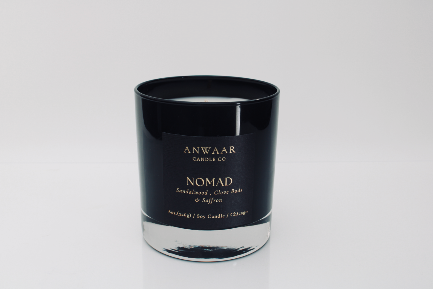 Nomad - black elegant candle vessel with black label and gold letters with details about the product  