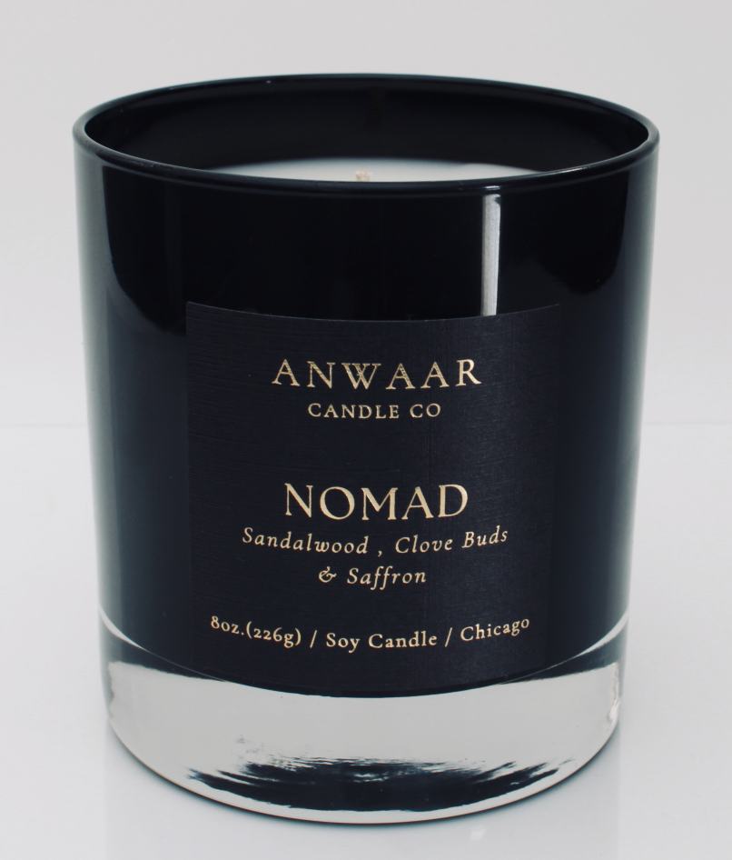 Nomad - black elegant candle vessel with black label and gold letters with details about the product 